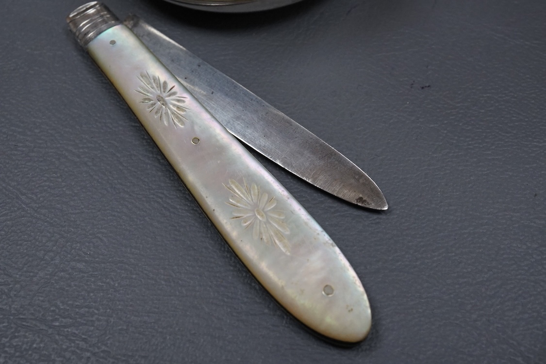An Edwardian silver and tortoiseshell pique mounted trinket box, by William Comyns, London, 1905, diameter 59mm, together with one other George V trinket box on tripod feet, two mounted glass scent bottles, a Victorian m